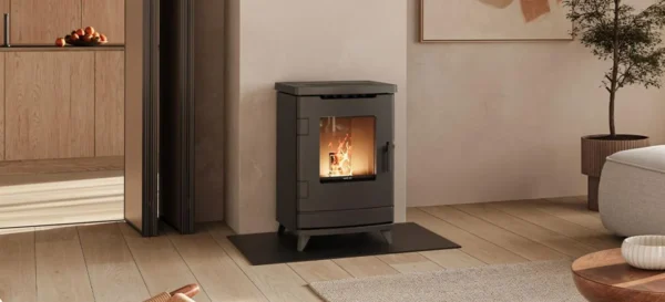 Zwarte pelletkachel met brandend vuur in moderne woonkamer met houten vloer en neutrale kleuren